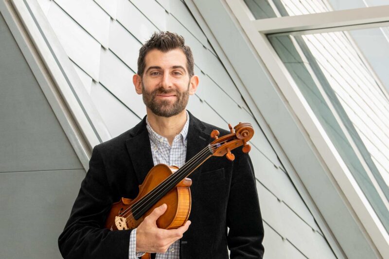 Headshot of Jonah Sirota holding a viola