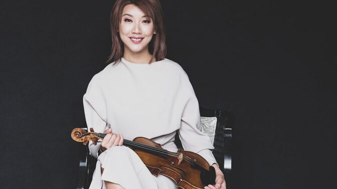 Fabio Kim smiling and holding her violin